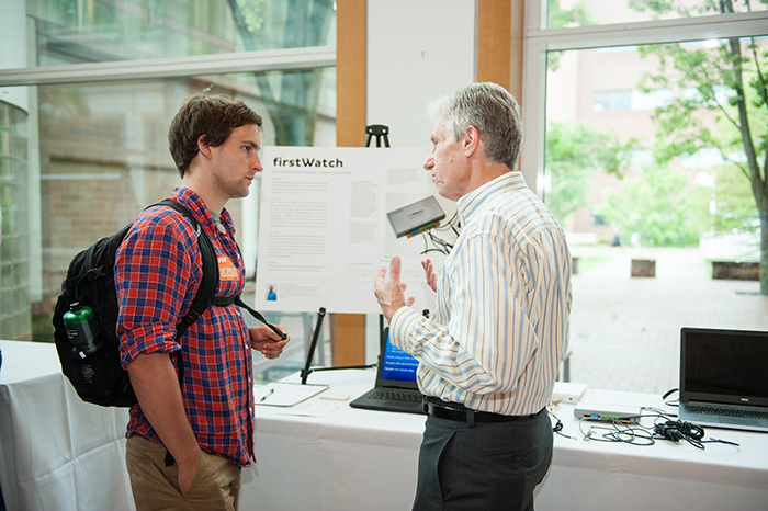 Joe Chipalowsky (right) shares his WiFi-enabled furnace-monitoring product, firstWatch, with a guest.
