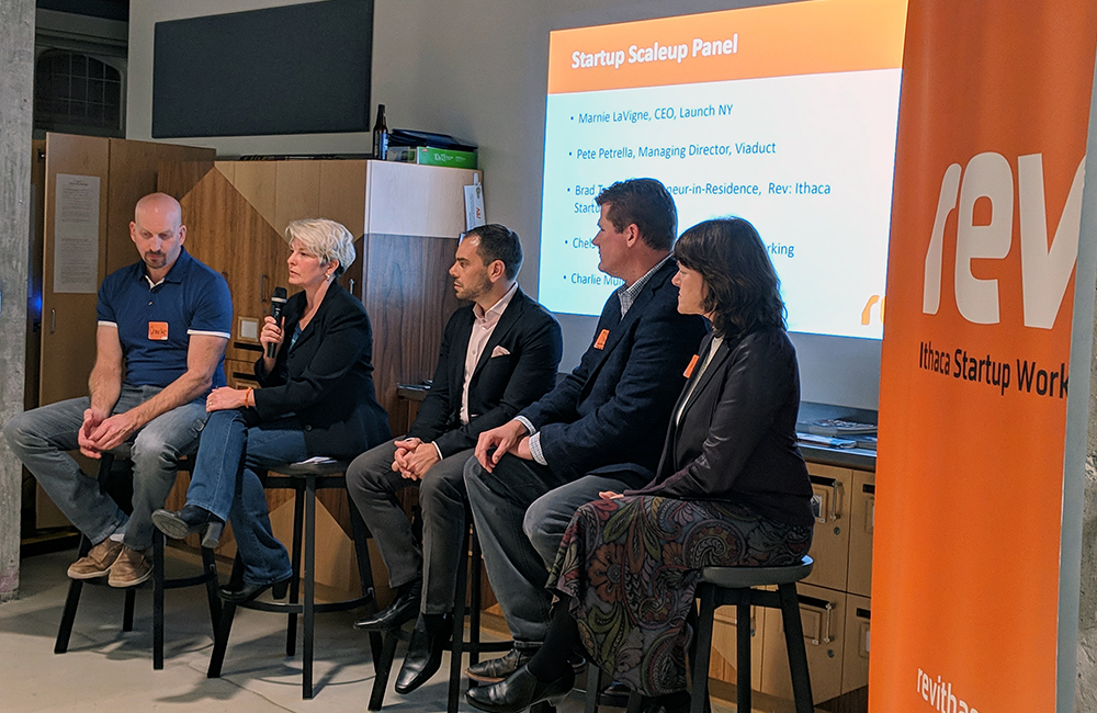 Charlie Mulligan, Chelsey Kingsley, Pete Petrella, Brad Treat, and Marnie Lavigne participate in a panel discussion on how to scale up a startup. Chelsey Kingsley is holding the microphone and speaking.