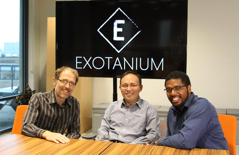 The Exotanium team sits at a table in front of the Exotanium logo.