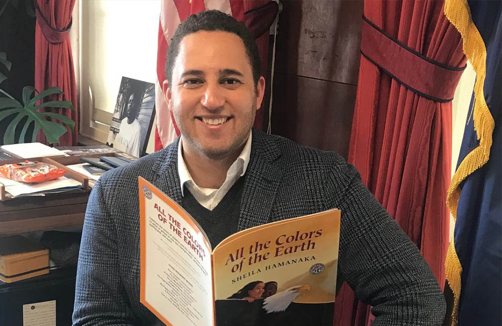 Ithaca Mayor Svante Myrick holds the book All the Colors of the Earth.