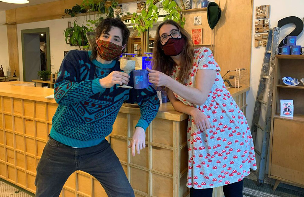Caleb Harrington of Nothing Nowhere Coffee and Megan Vidler of Home Green Home pose in masks in their new storefront on the Ithaca Commons.