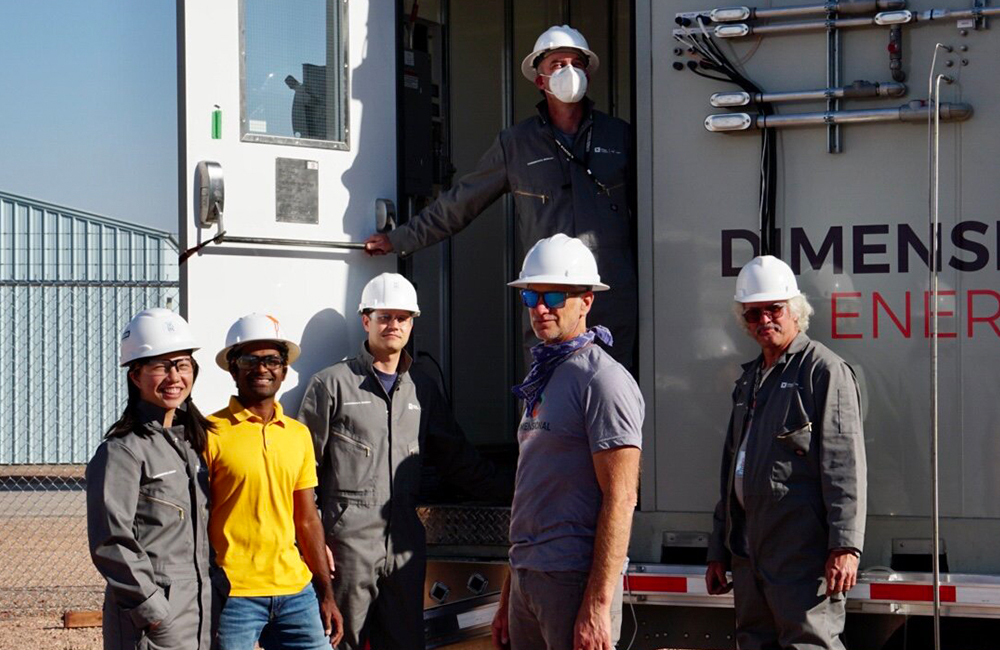 Members of the Dimensional Energy team stand in front of their trailer at a test site in Wyoming.