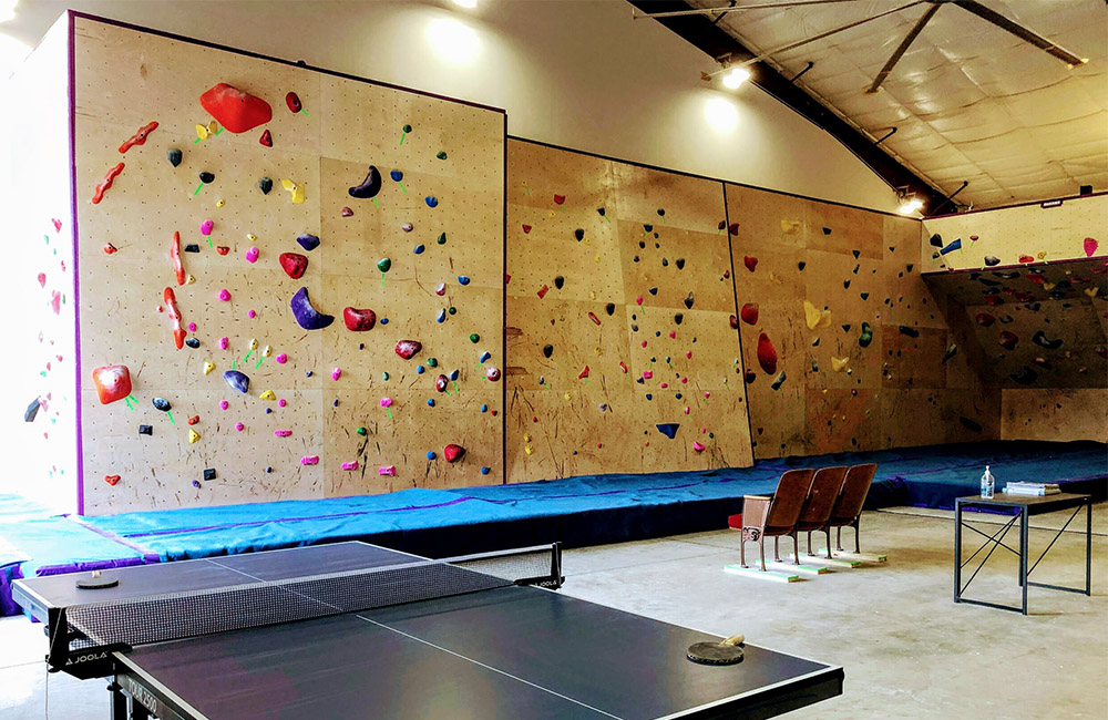 A ping pong table and a climbing wall at Cayuga Climbs, a climbing gym in Ithaca, New York.