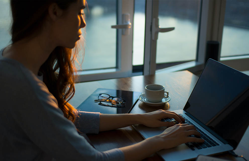 A woman sits at a computer.
