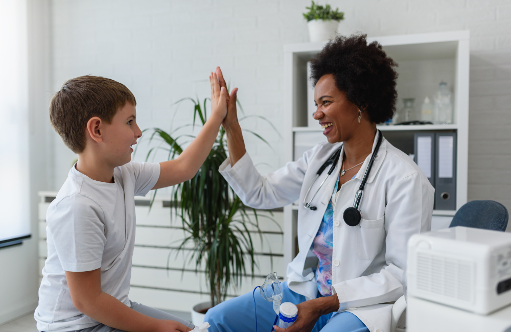 a young boy high fives a doctor