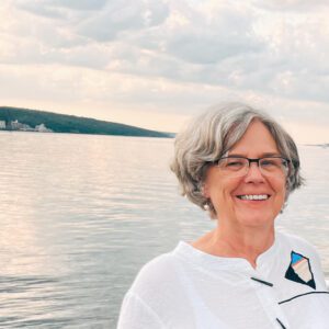 Image of Nancy Kirby standing infront of a calm lake.