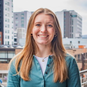 Image of Katharine Downey. White female wearing a turquoise cardigan.